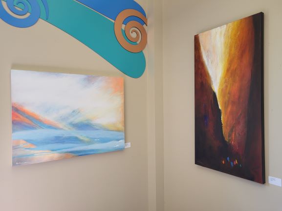 Two abstract paintings hanging on a wall.